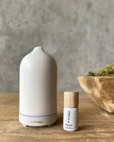 Minimalist stone scent diffuser next to cedarwood diffuser oil