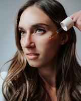 Dropping Skinne Facial Oil onto cheek