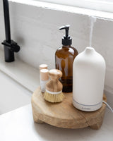 White stone minimalist kitchen diffuser next to diffuser oils